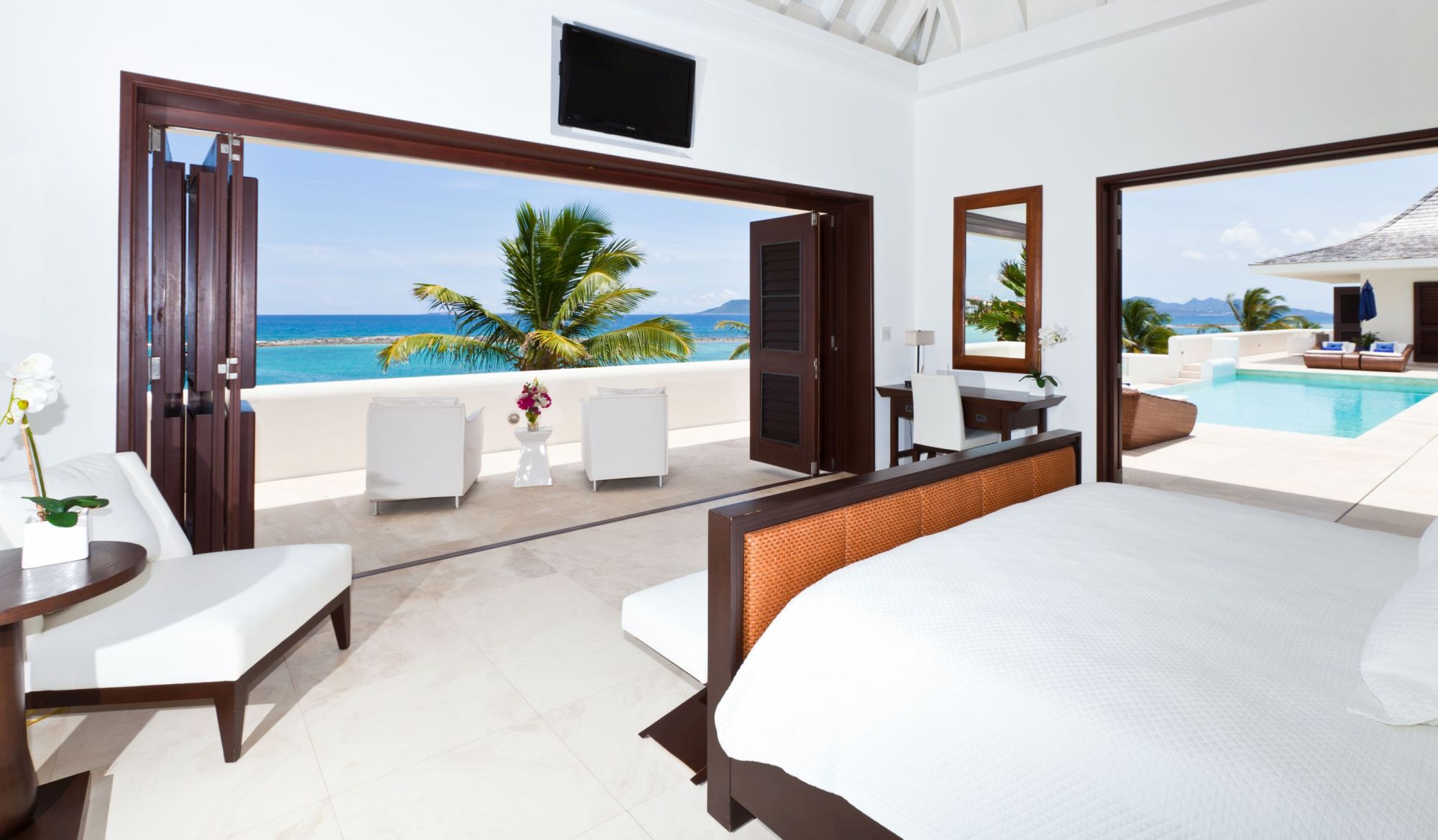 double bedroom with swimming pool and terrace access at le bleu, anguilla