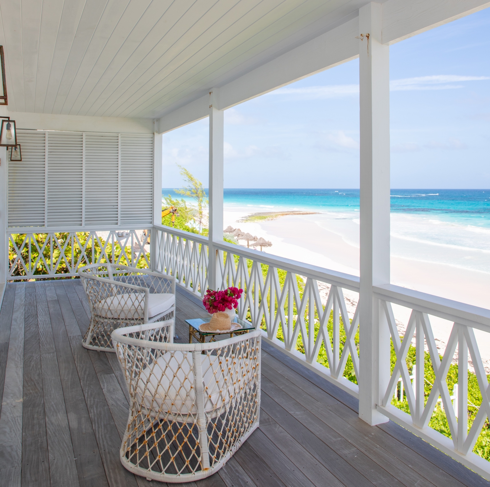 Balcony with comfy chairs, coffee table, flowers and sea view at Sea Siren in the Bahamas, Caribbean