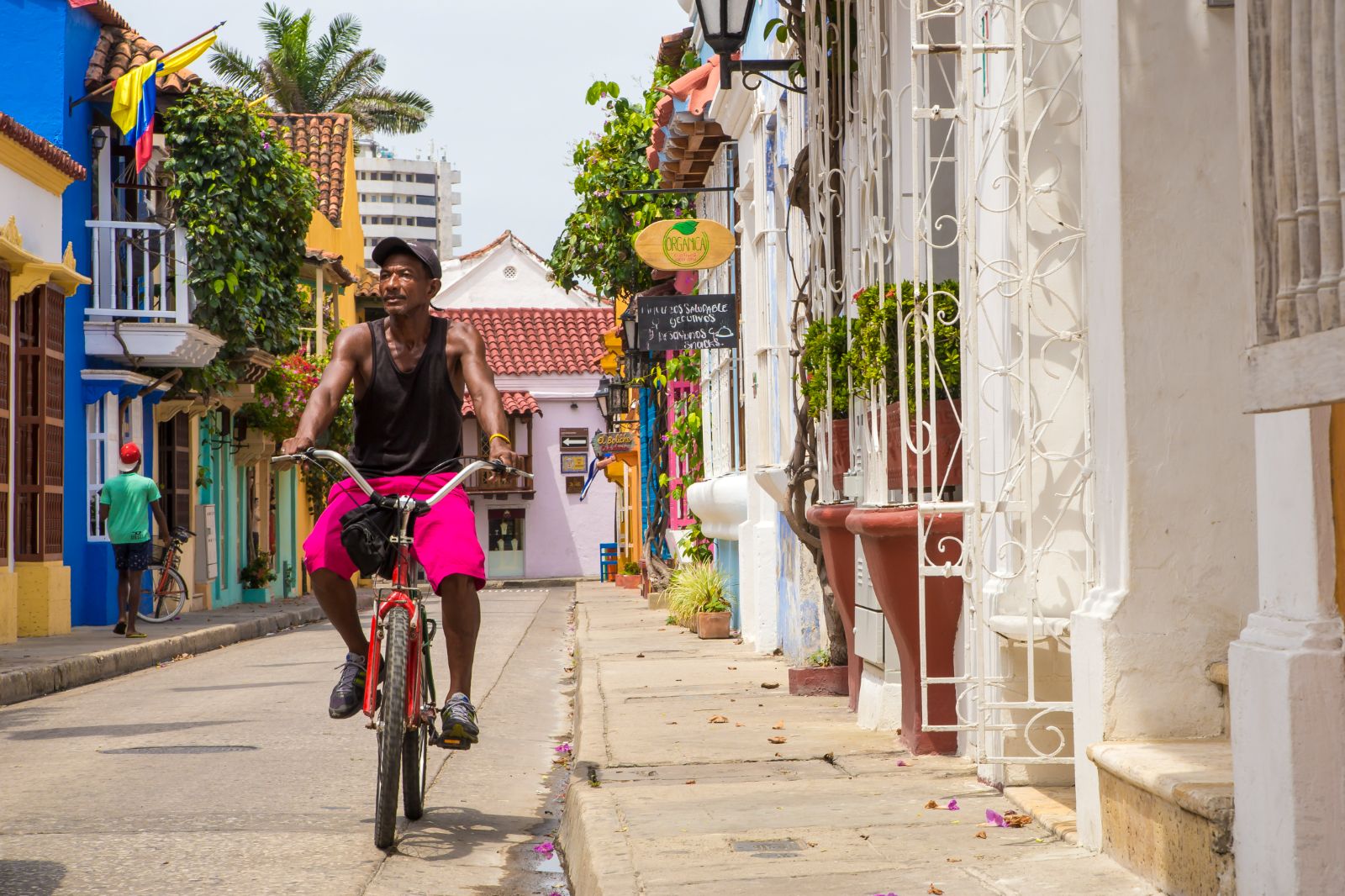 Local man cycling in the colourful streets of Cartagena, Colombia
