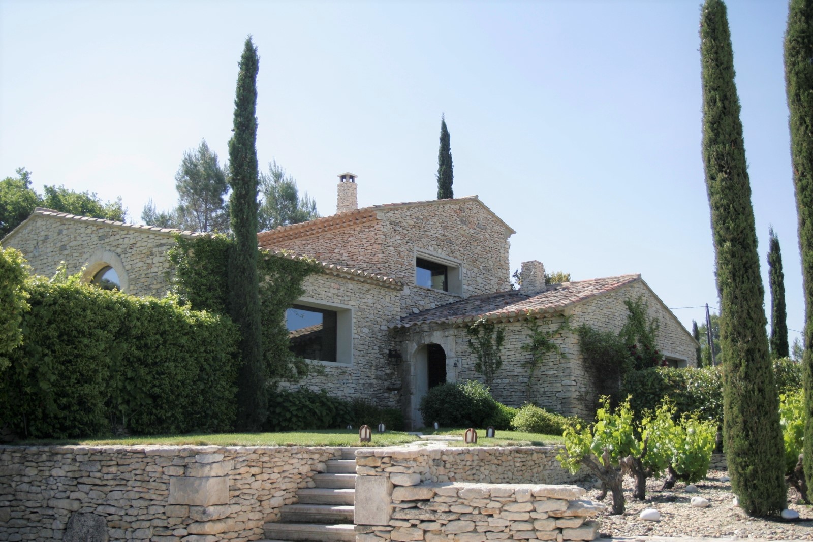 Façade and garden with vines and trees at Le Clos in Provence, France
