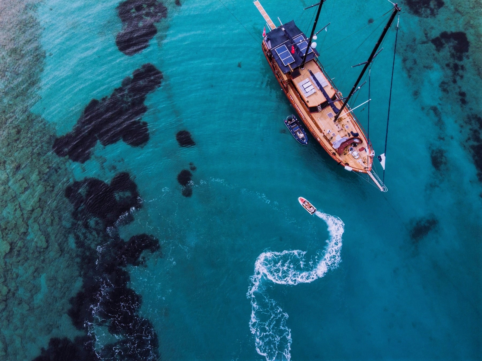 Aerial of Capricorn 1 with speedboat in blue water