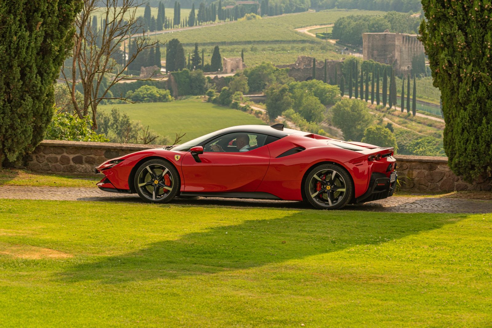 A red Ferrari parked at a viewpoint of Tuscany landscapes in Italy