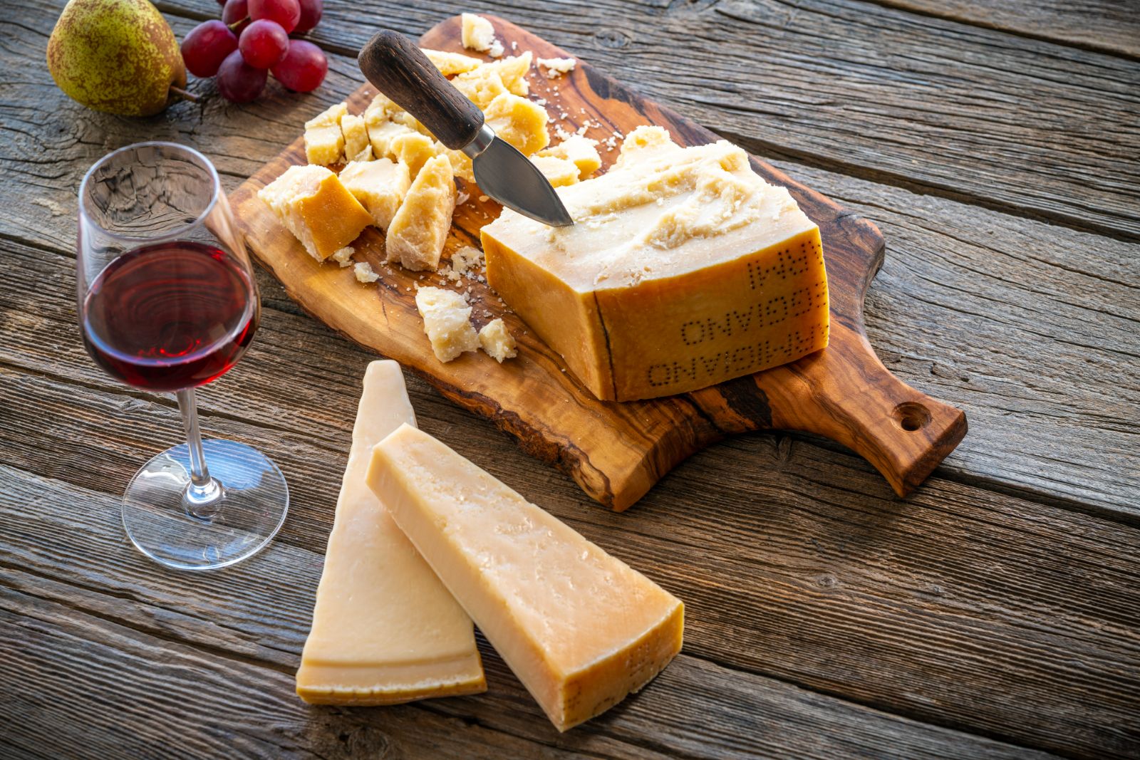 Glass of Italian red wine with a board of Parmigiano Reggiano cheese