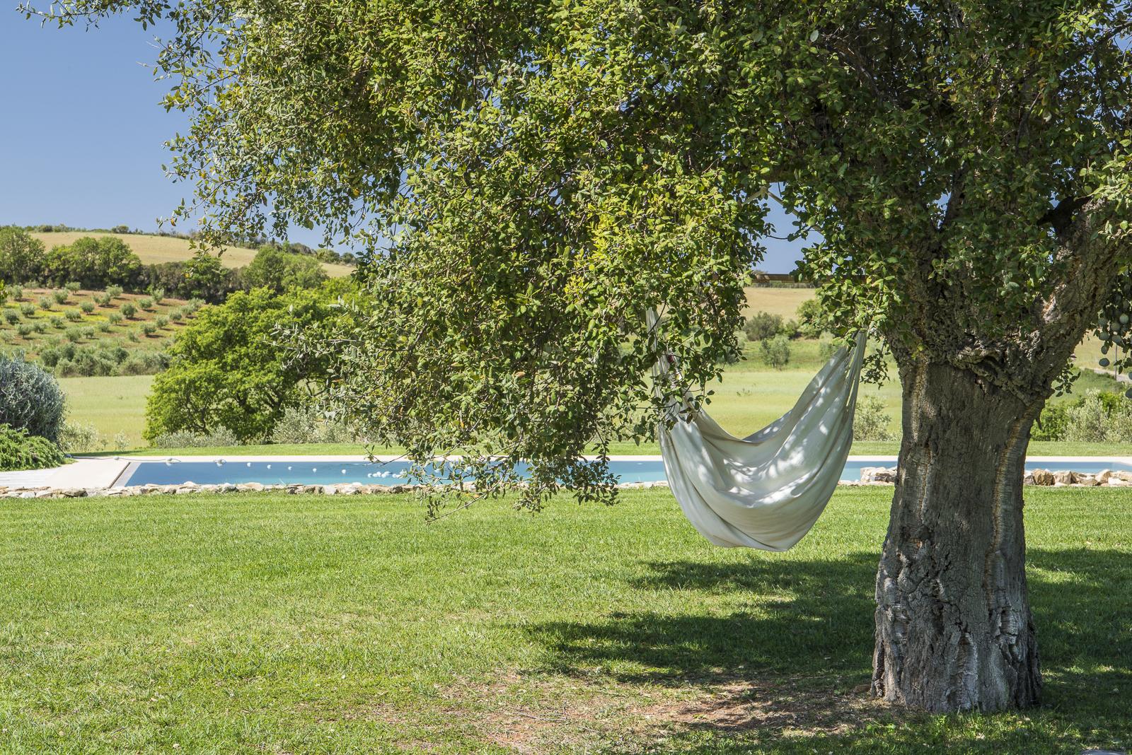 Hammock and swimming pool in the garden of Villa del Gelso, Tuscany