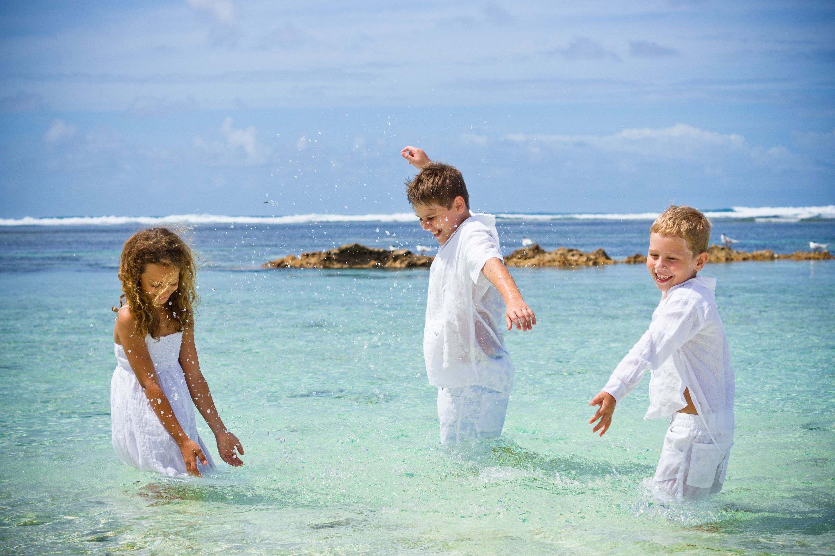 Children playing in the ocean at Denis Island, Seychelles