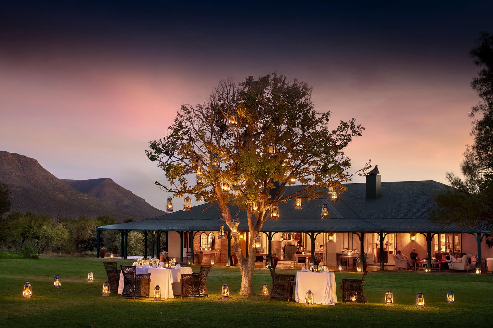 Outdoor dining at sunset at luxury safari lodge, Samara Karoo in South Africa.