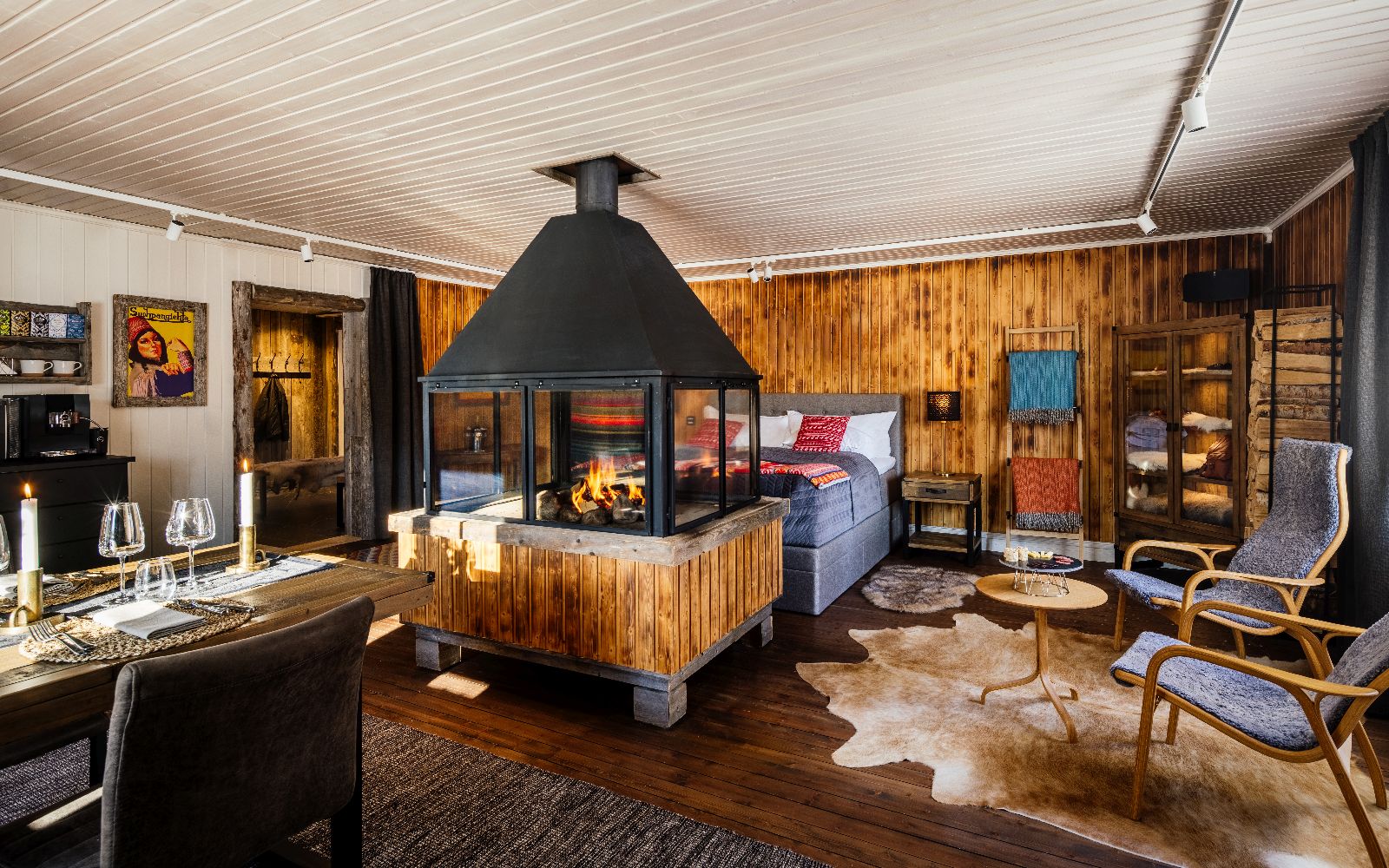 Cosy bedroom with indoor fireplace in luxury Loggers Lodge hotel in Sweden