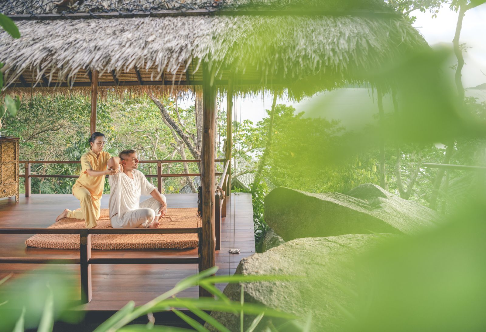 Guest enjoying a traditional Thai massage in an open treatment area at at luxury wellness resort Kamalaya in Thailand
