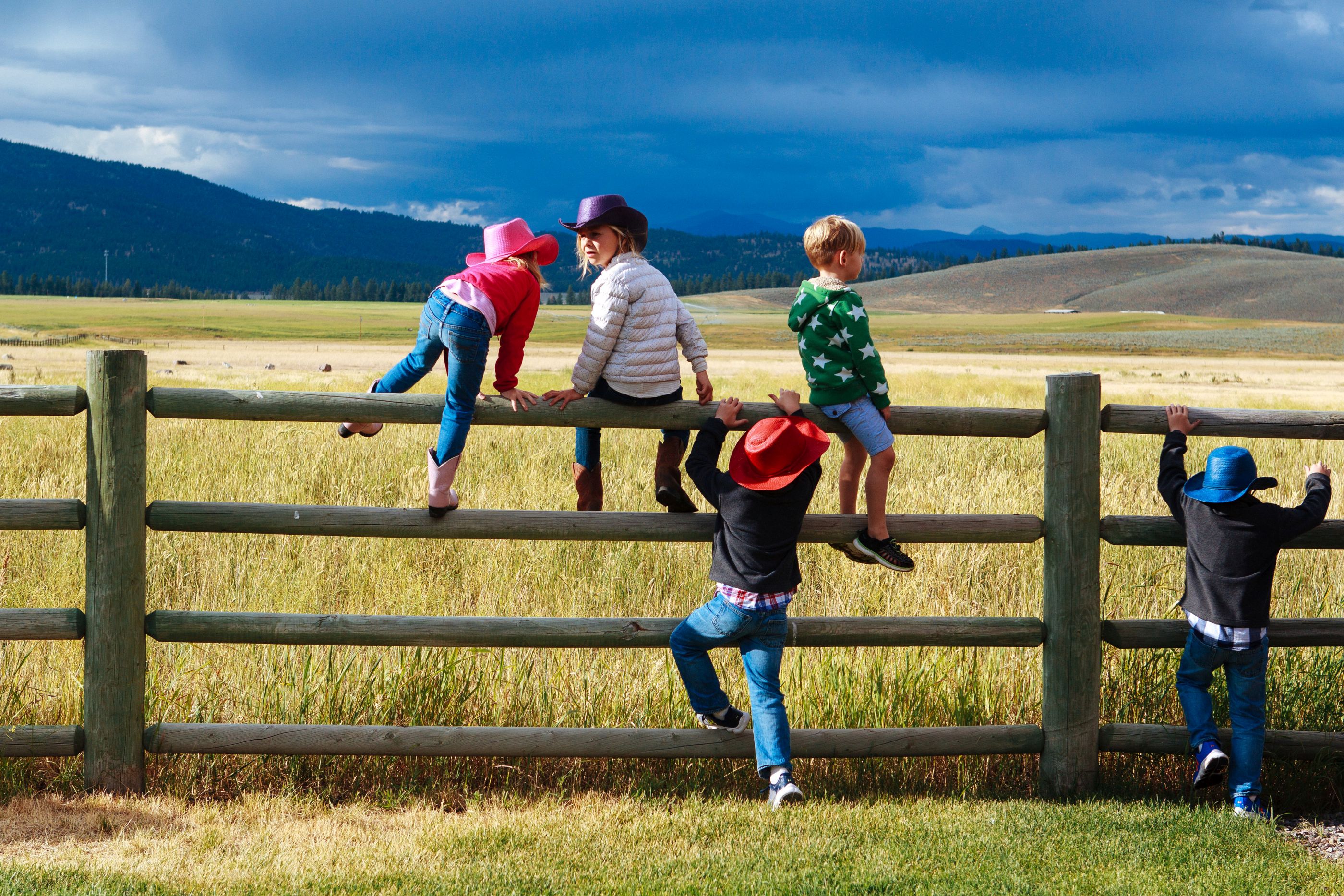 Children climbing a fence near Paws Up Ranch, USA